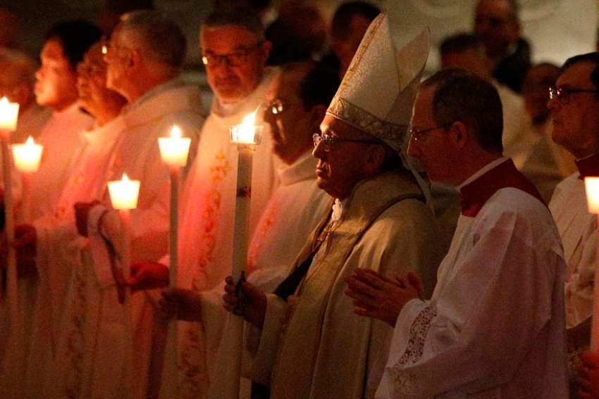 Pope Francis holds a candle as he arrives to celebrate Mass marking the feast of the Presentation of the Lord in St. Peter&#039;s Basilica at the Vatican Feb. 2.