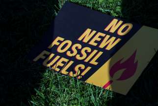 A sign protesting fossil fuels is seen on the lawn outside of the U.S. Capitol during a protest in Washington Oct. 18, 2019. 