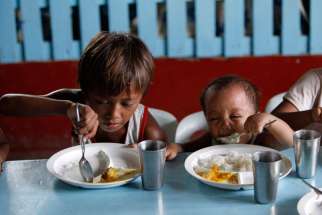 A boy and his younger brother eat their free meals during a feeding program in late May at a slum area in Manila, Philippines. Pope Francis denounced widespread hunger due to wasted food as a symptom of a &quot;throwaway culture&quot; and called for greater effort to build a worldwide &quot;culture of encounter and solidarity&quot; instead.