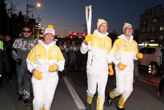 Senior officials of the International Physicians for the Prevention of Nuclear War and the International Campaign to Abolish Nuclear Weapons, both winners of the Nobel Peace Prize, carry the torch of the 2018 Pyeongchang Winter Olympics during a relay in Cheongju, South Korea.