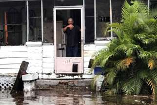 A man signals to police officers from a flooded house after Hurricane Irma passed through Daytona Beach, Fla. 