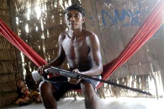 A member of the Tembe indigenous tribe, which is facing a conflict with illegal loggers on its land, holds his gun in Teko-haw indigenous village near Paragominas, Brazil, Sept. 9, 2019. A report released Sept. 24 from the Brazilian bishops&#039; Indigenous Missionary Council shows the number of indigenous murdered last year increased by more than 20% in comparison to 2017.