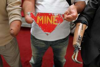 Land mine victims hold up a sign against the use of landmines. Pope Francis urged delegates to ban the production and use of landmines. 