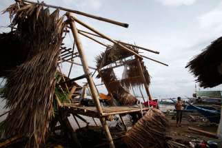 A Filipino July 17 stands next to his house destroyed by Typhoon Rammasun, locally named Glenda, in a coastal village in Batangas, south of Manila. Catholic Relief Services teams were fanning out to affected areas after Typhoon Rammasun propelled its way across the northern half of the Philippines, leaving at least 40 people dead and destroying more than 26,000 houses.