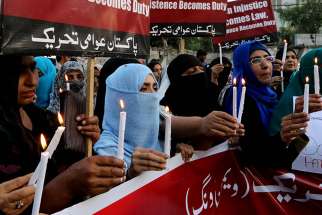 People hold candles during a March 29 gathering to mourn the victims of suicide bomb attack in Lahore, Pakistan. The terrorist attack in Lahore killed more than 70 and wounded more than 300 who were spending Easter afternoon in a public park. 