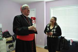 Toronto’s Cardinal Thomas Collins shares a laugh with Eman Jajoo Shakar as she gives him a tour of her new house. The Shakar family, the first Iraqi refugees welcomed by the Archdiocese of Toronto in 2009, now have their own home in Brampton, Ont.