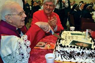 Msgr. Vincent Foy cuts the cake for his 100th birthday celebration with Cardinal Thomas Collins sharing the moment.