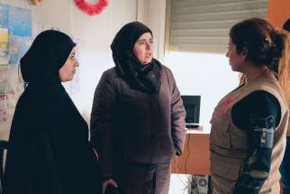 Pierrette Gabriel, right, a receptionist at the Caritas Lebanon center in Zahle, greets two Syrian refugee women seeking assistance for their families Jan. 4.
