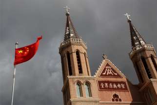 The Chinese national flag flies in front of a Catholic church in Huangtugang, China, Sept. 30, 2018. The Chinese government has targeted unregistered Catholic and Protestant churches with an expansion of rules and regulations governing religious organizations.