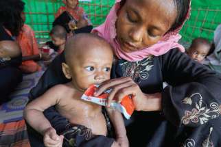A woman from Myanmar feeds her child in a UN clinic for severely malnourished Rohingya children Oct. 28 in the Balukhali Refugee Camp near Cox’s Bazar, Bangladesh. More than 600,000 Rohingya have fled government-sanctioned violence in Myanmar for safety in Bangladesh.