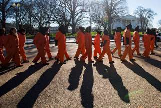 Activists dressed in orange jumpsuits representing detainees in the U.S.-run detention centre at Guantanamo Bay, Cuba, rally in front of the White House Jan. 11 asking President Barack Obama to close the facility and release or charge the dozens of men being held there.