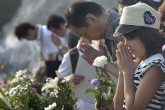 People pray at a memorial in Hiroshima, Japan, Aug. 6, to commemorate the victims of the atomic bombing of the city by the United States in 1945. Delegation members from the World Council of Churches, in Hiroshima for the commemoration, said they would return home to build a movement to rid the world of nuclear weapons.