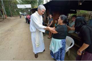 Jesuit Father Jose Antonio Pacheco greets gold mine protesters during Mass along a road in La Puya, Guatemala, Dec. 7. Mining has divided the church in Guatemala, with environmentalist Bishop Alvaro Ramazzini of Huehuetenango receiving death threats.