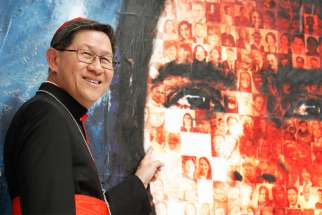 Philippine Cardinal Luis Antonio Tagle of Manila, president of Caritas Internationalis, points to a photo of his maternal grandfather, who emigrated from China to the Philippines. 