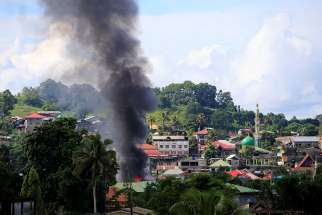 Smoke billows from a burning building as government troops continued their assault on Islamic militants June 1 in Marawi, Philippines.
