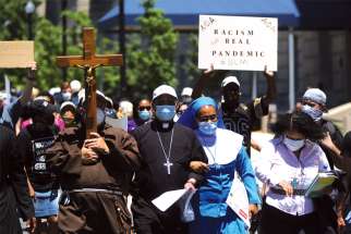 Washington Auxiliary Bishop Roy E. Campbell and a woman religious walk with others toward the National Museum of African American History and Culture during a protest June 8, following the death of George Floyd.