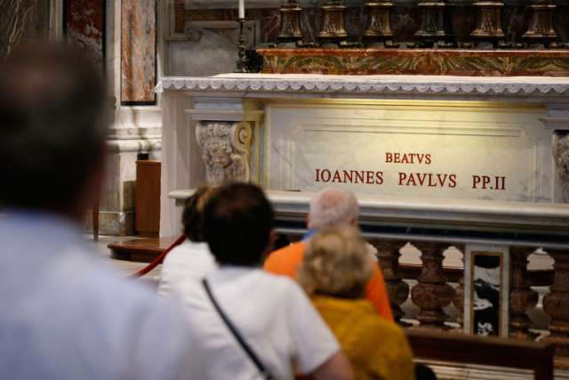 People pray at the tomb of Blessed John Paul II in St. Peter&#039;s Basilica at the Vatican. Every day, countless pilgrims leave letters and notes addressed to him.