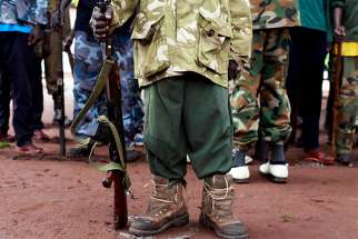 In this file photo, a former child soldier in Yambio, South Sudan, holds a gun during a child soldiers&#039; release ceremony. Catholic bishops in South Sudan and Sudan appealed to the citizens of the two countries to work harder for peace, telling them, &quot;True peace can only be built by citizens like you.&quot; 