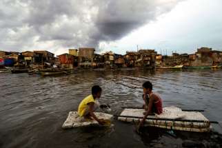 Children paddle in water in Navotas City, Philippines, May 10.