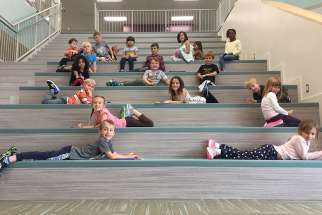 Grade one students relaxing on Ecole St. Elizabeth’s presentation stairs.  