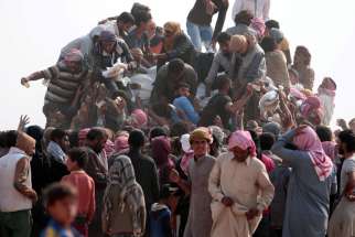 Iraqi refugees that fled violence in Mosul and internally displaced Syrians who fled Islamic State controlled areas in Deir el-Zour buy food and water at the Syrian border near Hassakeh.