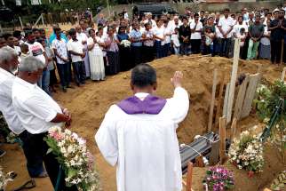 A clergyman prays over the casket of 13-year-old Dhami Brindya during her burial in Negombo, Sri Lanka, April 25, four days after suicide bomb attacks on churches and luxury hotels across the island. 