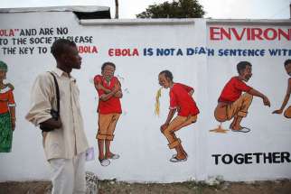 A Liberian man looks at an Ebola sensitization campaign painted on a wall in downtown Monrovia, Liberia, Nov. 19. More cooperation is needed between the international community and faith leaders in stemming the ongoing Ebola epidemic, said a joint commun ique issued by the United Nations and the World Council of Churches.