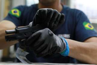 An employee from gun manufacturer Taurus Armas SA works at the company&#039;s assembly line in Sao Leopoldo, Brazil. Brazilian President Jair Bolsonaro signed a decree Jan. 15 making it easier for Brazilians to purchase firearms. The decision sparked criticism from several groups in Brazilian society, including some in the Catholic Church. 