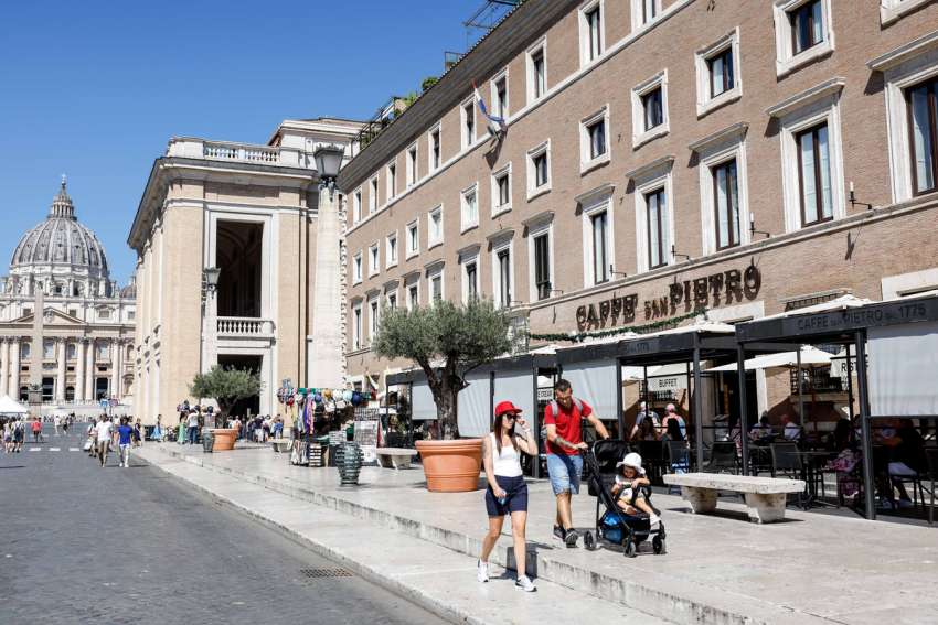 Pilgrims and tourists walk along the Via della Conciliazione near St. Peter&#039;s Square and St. Peter&#039;s Basilica Aug. 15, 2023. The broad avenue is lined with many Vatican-owned buildings either used for Vatican offices and residences or rented out to earn money.