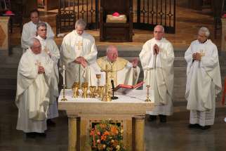 Bishop William F. Murphy of Rockville Centre, N.Y., and other bishops celebrate Mass facing the audience.