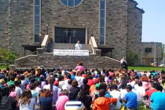 Students and staff of St. Catherine of Siena Separate School gathered at the church for a prayer service led by Fr. Camillo Lando May 28. The St. Catherine school has pledged to pay for a new statue of the Sacred Heart of Jesus following a third attack of vandalism on the church grounds May 20.