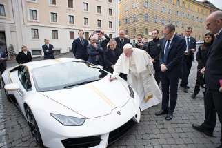 Pope Francis autographs a Lamborghini Huracan coupe presented by representatives of the Italian automaker at the Vatican in this 2017 file photo. The custom-built 2018 Lamborghini is back on the block, this time with an online fundraising platform, not at an elite European auction house. 