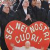 Sister Benedetta Favreau holds a sign saying in Italian &quot;You are in our hearts,&quot; as she attends Pope Benedict XVI&#039;s recitation of the Angelus from the window of his apartment overlooking St. Peter&#039;s Square at the Vatican Jan. 15.