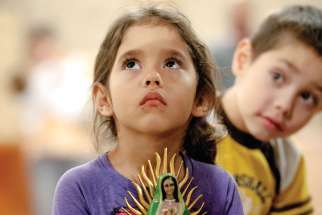 Five-year-old Nicole Vicente holds a statue of Our Lady of Guadalupe to be blessed during a Dec. 11 Mass celebrating the anniversary of the appearance of Mary to St. Juan Diego in 1531. The Mass was celebrated at St. Joseph Church in Penfield, N.Y.