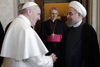 Pope Francis greets Iranian President Hassan Rouhani during a private meeting at the Vatican Jan. 26. Looking on is is Archbishop Georg Ganswein, prefect of the papal household.