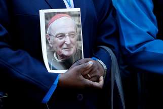A mourner holds a portrait of Cardinal Joachim Meisner of Cologne, Germany, prior to his funeral July 15.