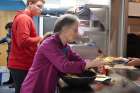 Bonnie DeSilva hands a plateful of breakfast to a guest during St. Stephen-in-the-Fields&#039; Saturday breakfast program.