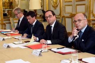 French Prime Minister Manuel Valls, second from left; President Francois Hollande, third from left; and Interior Minister Bernard Cazeneuve, right, look on during a meeting with French representatives of religious communities at the Elysee Palace in Paris on July 27, 2016.