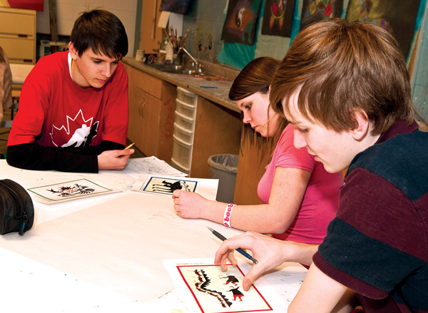 Grade 9 Fr. John Redmond Catholic Secondary students Illia Nikulchuck, Jacinta Judge and Roman Makuch, above, work with woodland style native images in their art class. Makuch thinks of his art classes as lessons in Canadian culture. 