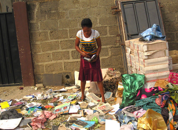 A woman picks through the belongings of the bomb victims at St. Theresa’s parish looking for the Bible of a dead relative.