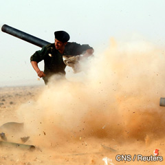 A rebel fighter fires a cannon during a battle with forces loyal to Col. Moammar Gadhafi near Ras Lanuf, a major oil port in Libya. The Pope has called for a sus- pension of fighting and for a start to dialogue to restore peace. (CNS photo/Goran Tomasevic, Reuters)