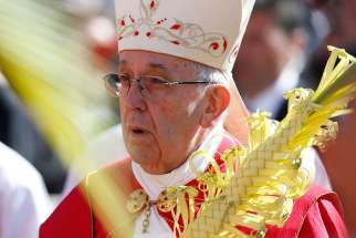 Pope Francis carries palm fronds in procession during Palm Sunday Mass in St. Peter&#039;s Square at the Vatican April 9.