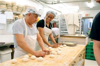 Chimal and Wendy exchange jokes as they knead a batch of English muffins at Toronto’s St. John’s Bakery.