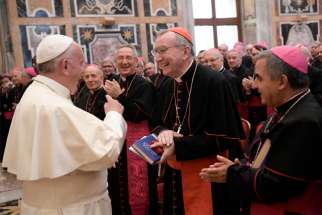 In this 2016 file photo in the Vatican&#039;s Apostolic Palace, Pope Francis talks with Cardinal Pietro Parolin, Vatican secretary of state, and Archbishop Giovanni Angelo Becciu, right, during a meeting with nuncios, who represent the pope around the world.