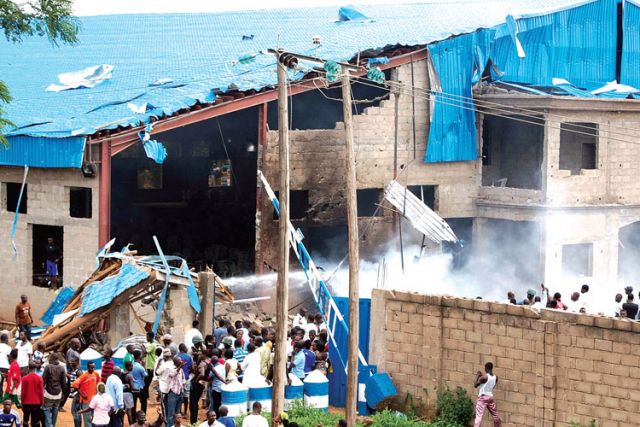 People gather near the damaged Shalom Church after a deadly bombing in 2012 in the northern Nigerian city of Kaduna.
