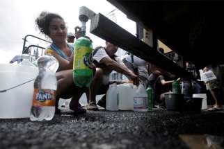 People collect clean drinking water from a tanker sent by government authorities as part of measures to help prevent the spread of the coronavirus in San Jose, Costa Rica, March 14, 2020. The Vatican said defending the right to clean water is part of the Catholic Church&#039;s promotion of the common good.