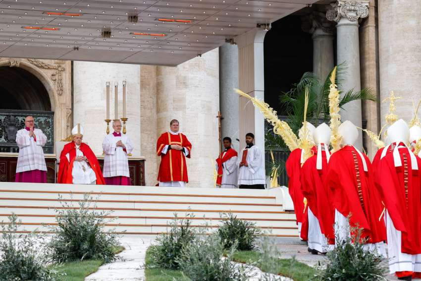 Prelates carry palm fronds in procession as Pope Francis looks on at the start of the celebration of Palm Sunday Mass in St. Peter&#039;s Square at the Vatican March 24, 2024.