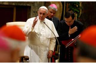 Pope Francis delivers his blessing during an audience to exchange Christmas greetings with members of the Roman Curia in Clementine Hall at the Vatican Dec. 22.