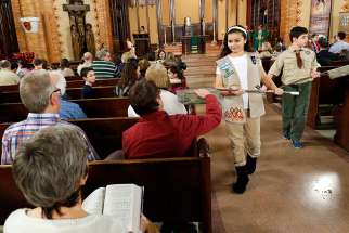 Girl Scout Julia Ocasio, 13, and Boy Scout Thomas Perotta, 10, use collection baskets during a Scout Sunday Mass Feb. 7 at Immaculate Heart of Mary Church in the Windsor Terrace neighborhood of the New York borough of Brooklyn.