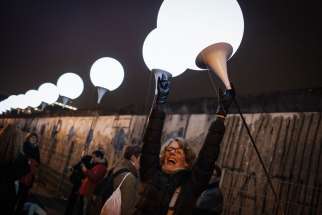A woman celebrates as she awaits the release of balloons into the sky along the former path of the Berlin Wall in Berlin Nov. 9. Commemorating the 25th anniversary of the fall of the Berlin Wall, Pope Francis said the sudden end to the division of Europe was prepared by the prayers and sacrifice of many people, including St. John Paul II. 